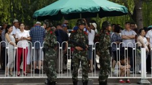 Paramilitary soldiers stand guard in front of visitors in a queue to undergo security checks before entering Tiananmen Square in Beijing