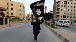 A member loyal to the ISIL waves an ISIL flag in Raqqa